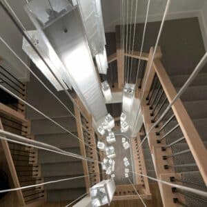 Cascading Murano glass chandelier above modern staircase