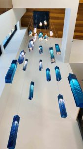 SunBeam cascading pendant lights suspended from double-height ceiling