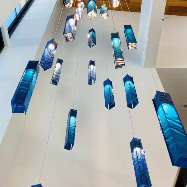 SunBeam cascading pendant lights suspended from double-height ceiling
