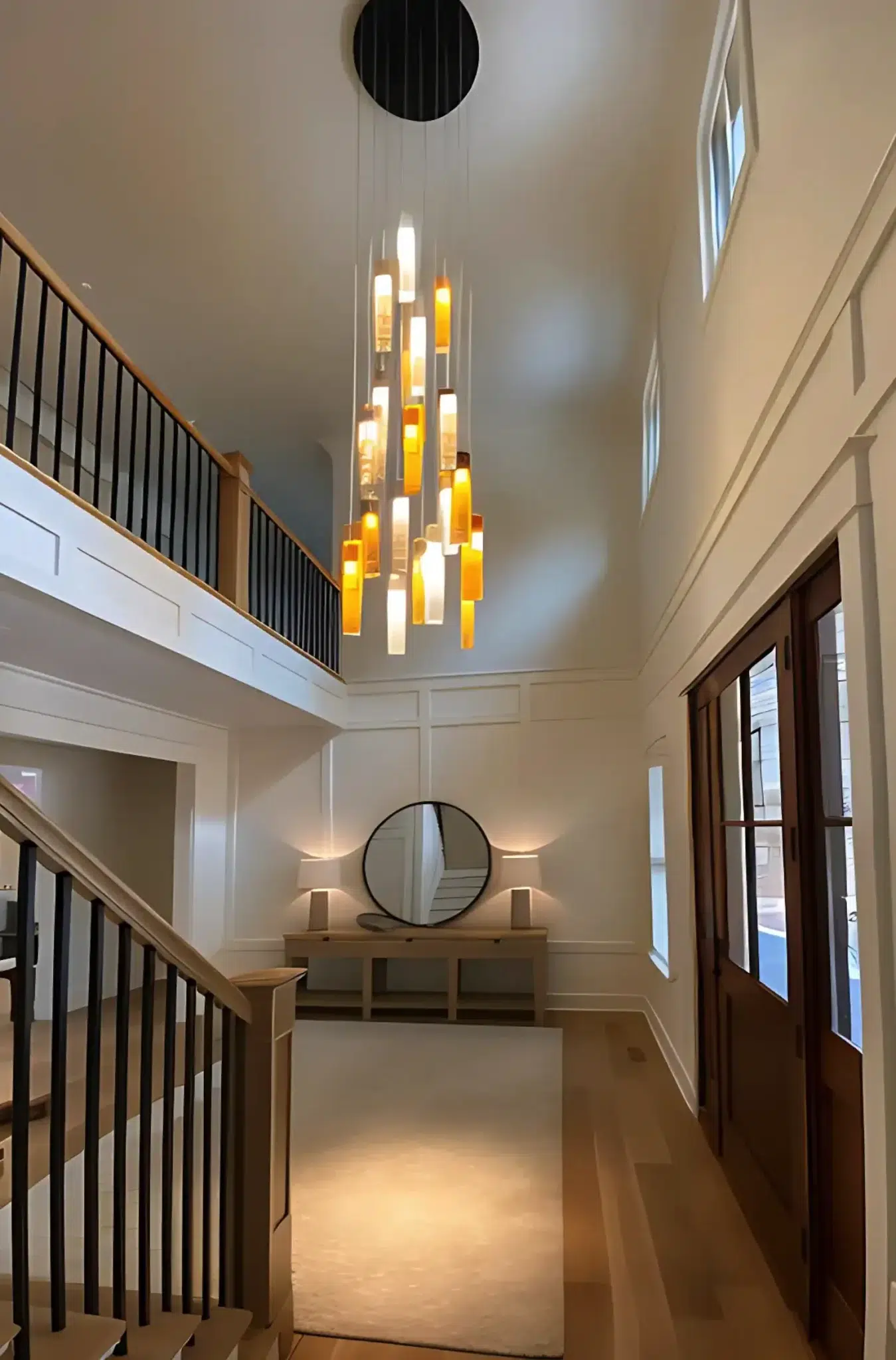 Elegant SunBeam art glass chandelier in double-height foyer crafted in multi-color glass